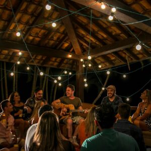 An intimate musical gathering under string lights in São Paulo, Brazil.