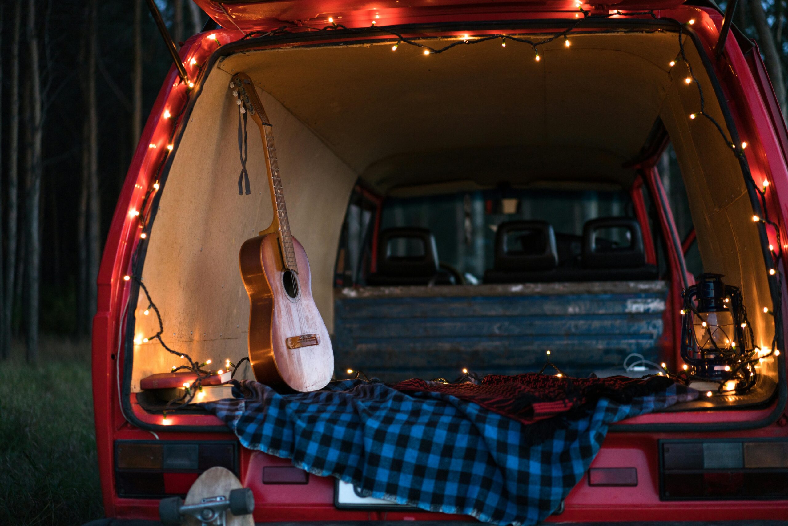pexels photo 4572121 4572121 A serene camping scene with an acoustic guitar and lights in a car trunk, perfect for music lovers.