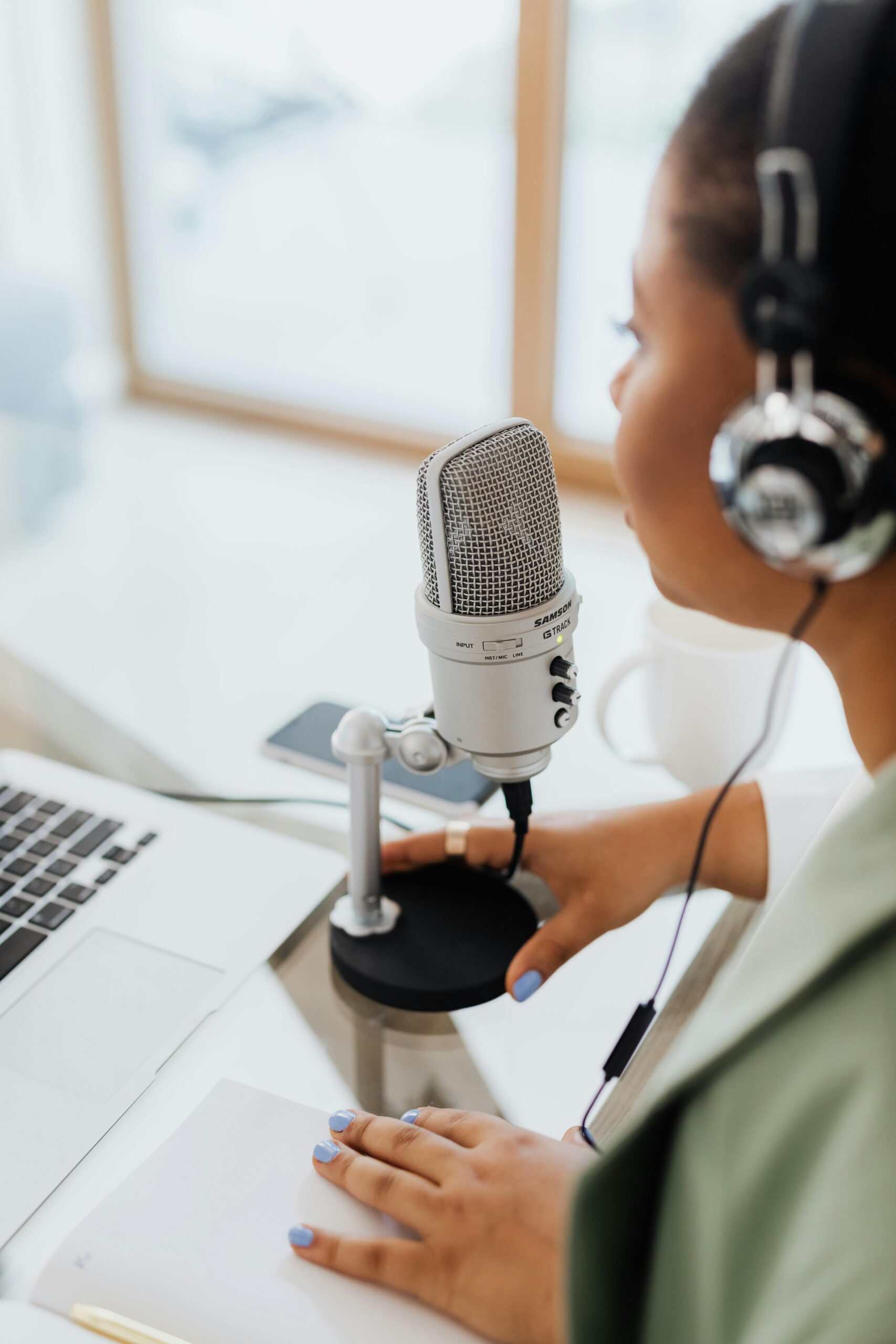 pexels photo 5399016 5399016 A woman wearing headphones recording a podcast at home using a professional microphone and laptop.